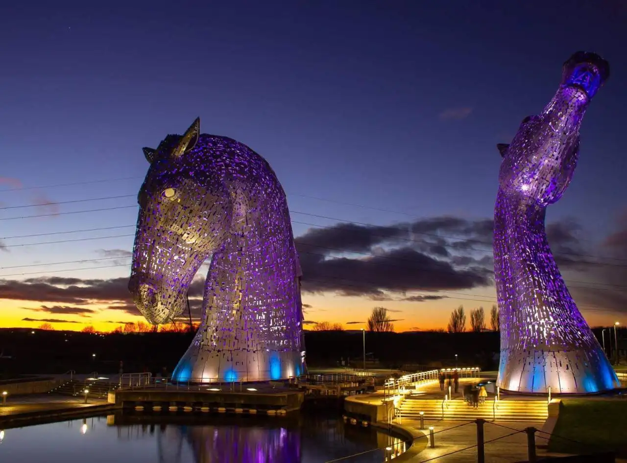 The Kelpies sculptures at sunset with purple lighting