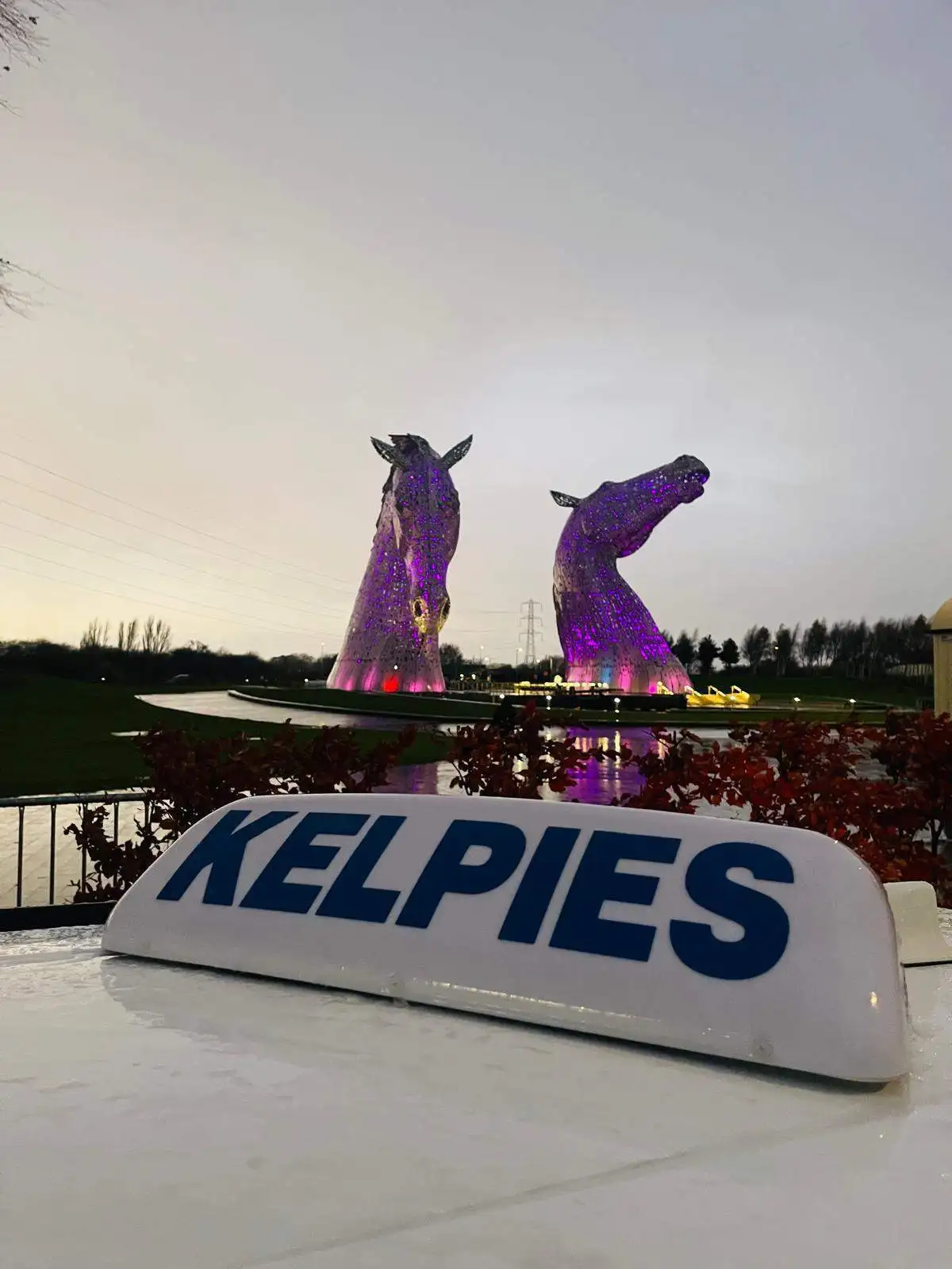 Kelpies Cabs private hire vehicle in front of The Kelpies sculptures
