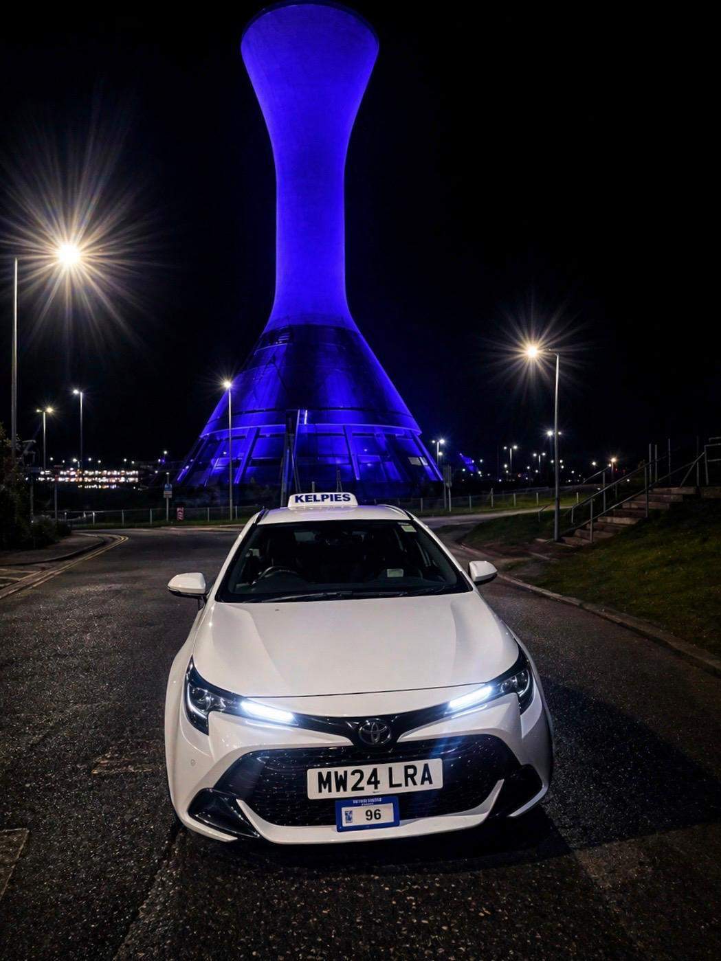 Kelpies Cabs private hire vehicle at night near Falkirk landmark