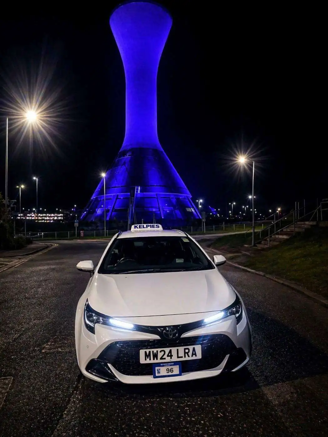 Kelpies Cabs private hire vehicle at night near Falkirk landmark